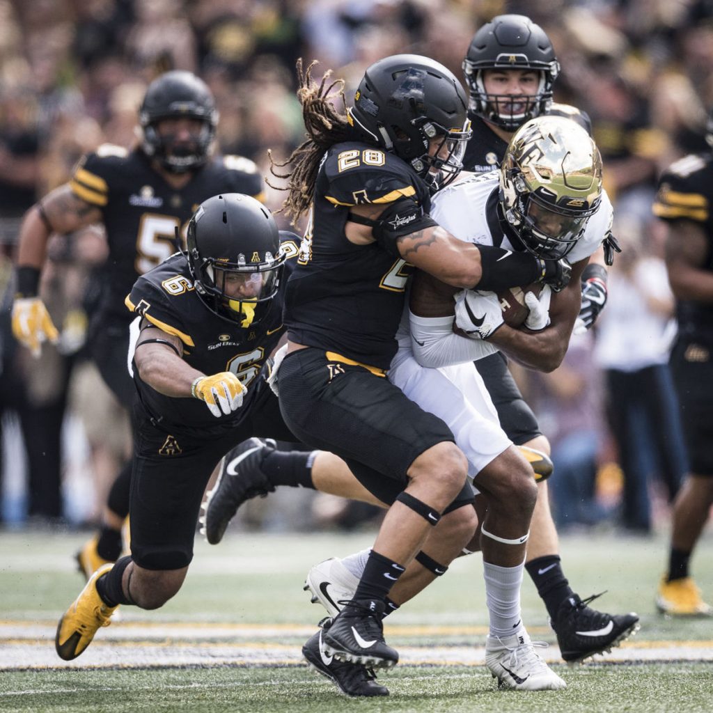 Wake Forest wide receiver Scotty Washington is tackled after a reception and run by App State linebacker Devan Stringer (28) on Saturday in Boone. (Andrew Dye/Winston-Salem Journal)